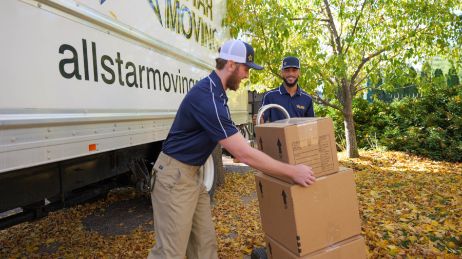 two workers loading boxes onto a dolly