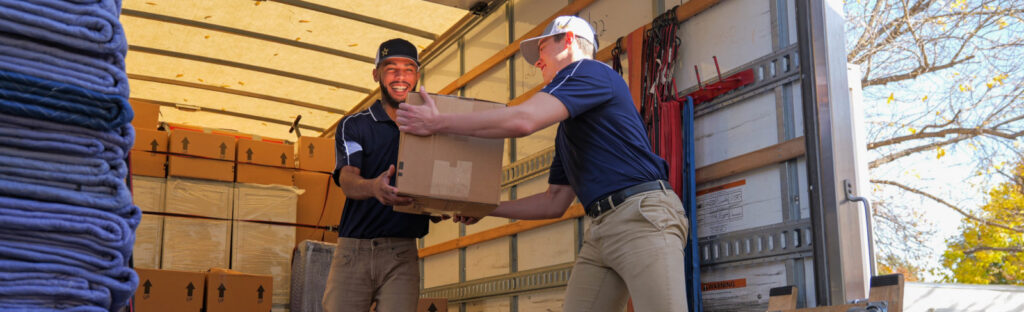 two movers unload a moving truck