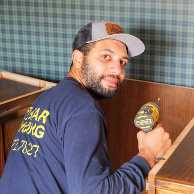 person disassembling furniture with drill